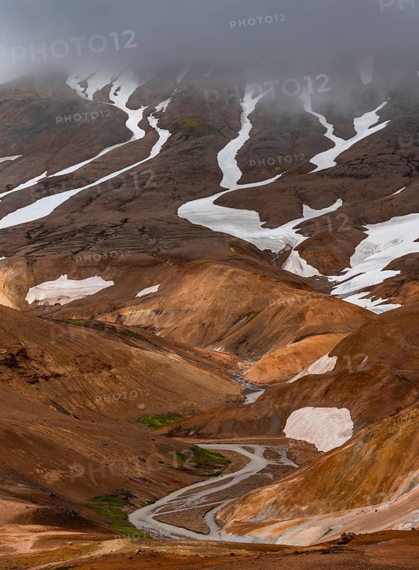 Stream between colourful rhyolite mountains with snowfields, Hveradalir geothermal area, Kerlingarfjöll, Icelandic highlands, Iceland