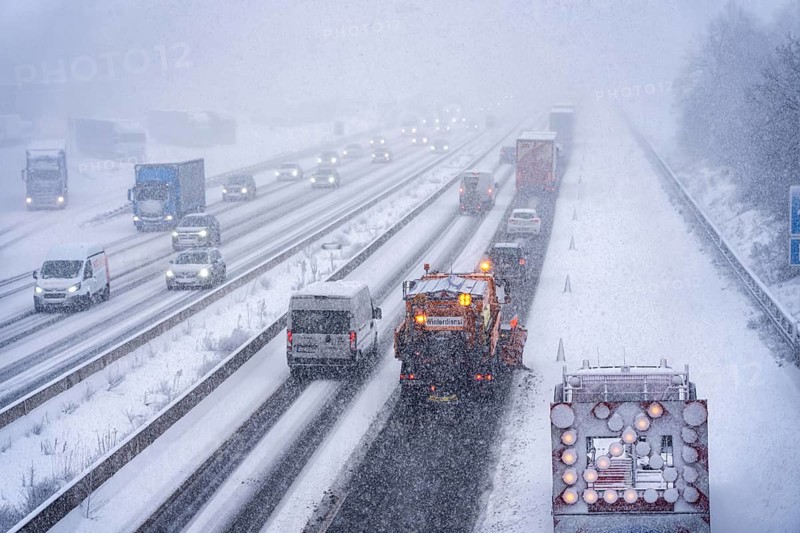 The onset of winter in North Rhine-Westphalia, heavy snowfall, A3 motorway near Hilden, near Ohligser Heide rest area, snow-covered roads, winter service at the motorway maintenance department with clearing vehicles, traffic is sometimes just stalling, North Rhine-Westphalia, Germany