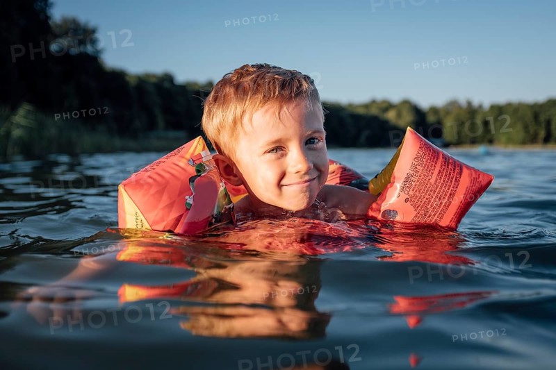 5-6 year old boy learns to swim. Active happy child wearing safe swimmies in Tymowa, Poland