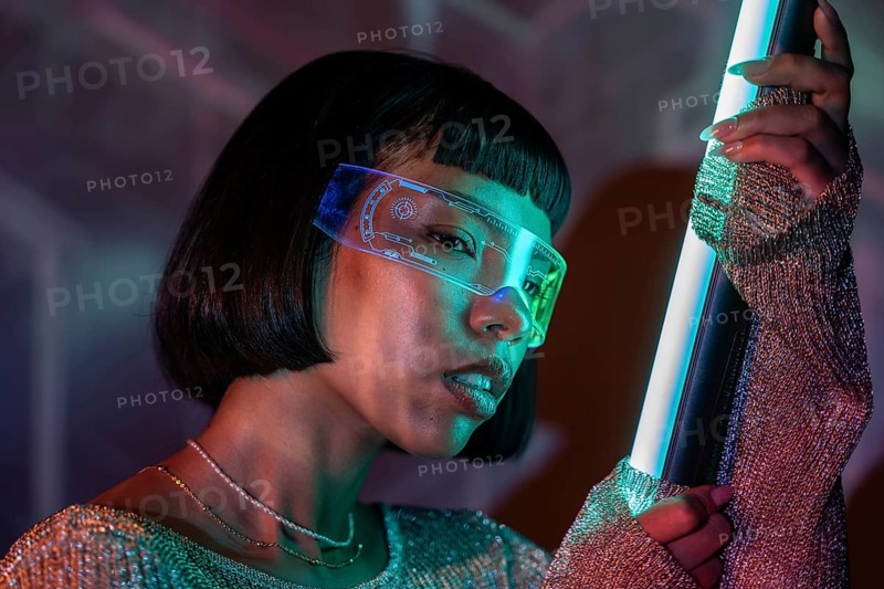 Latin woman wearing futuristic virtual reality glasses, immersed in a captivating digital experience. Neon lights cast a vibrant glow, highlighting the modern technology theme