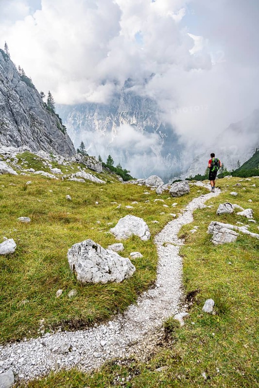 Mountaineer on a hiking trail, cloudy mountains, descent over the Ofental, mountain tour on the Hochkalter, Hochkalter crossing, Berchtesgaden Alps, Bavaria, Germany