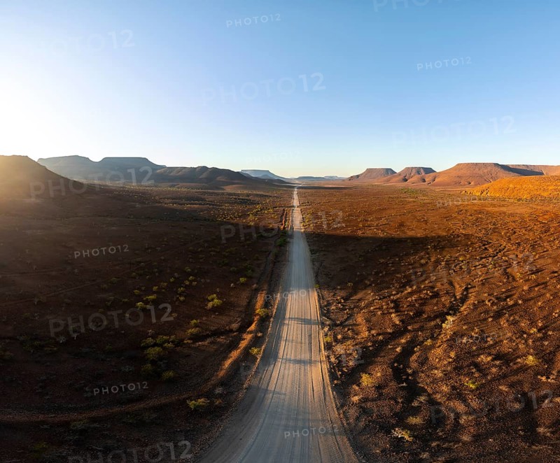 Aerial view, infinite space, straight road leads through dry desert landscape, hills in Damaraland, Namibia