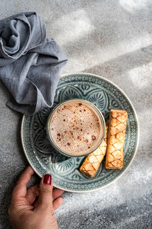 A delightful puff pastry filled with sweet apricot jam served alongside a freshly brewed cup of rich cocoa, creating a perfect indulgent snack experience
