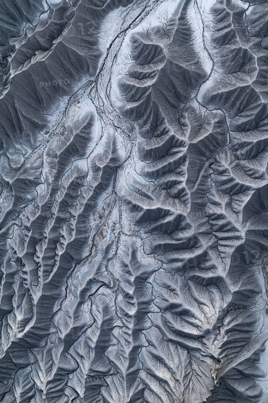 A captivating aerial shot captures the complex textures and natural patterns of Caineville Mesa near Hanksville, Utah, showcasing erosion and geological layers