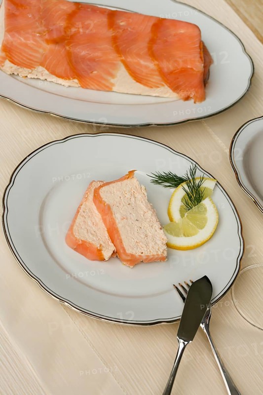 Southern German cuisine, salmon trout terrine arranged on a plate, salmon terrine with trout fillets, fish dish, salmon fillets, smoked salmon, starter, fine dining, Sunday crockery with gold rim, grandma's service, lemons, dill, fish cutlery, food photography, studio, Germany
