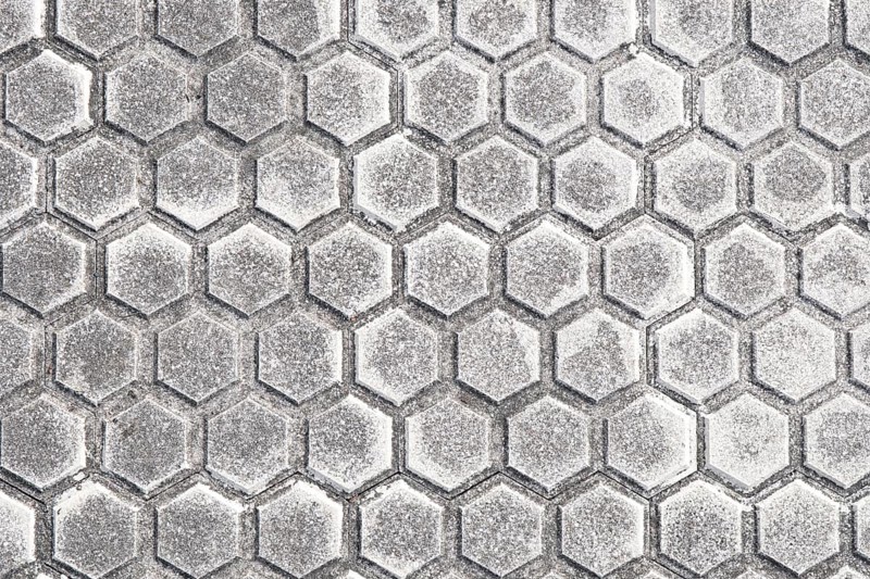 Close-up of a modern pavement featuring hexagonal tile patterns, detailed with subtle gray shades, suitable for backgrounds and urban design themes