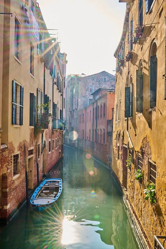 View on a waterway with boats lying in the water in Venice on a sunny day in winter, Italy