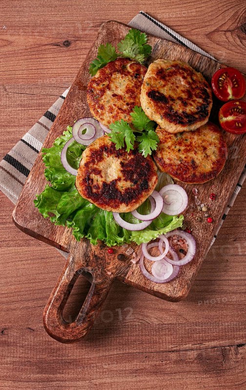 Fried chicken cutlets, minced chicken, with vegetables, on a cutting board, with vegetable salad, top view, homemade, no people