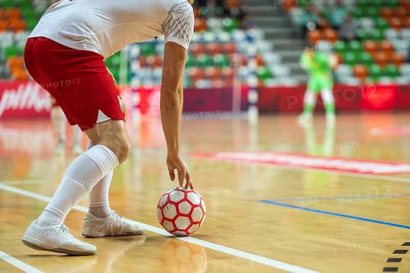 Detail of futsal ball and player out of the court