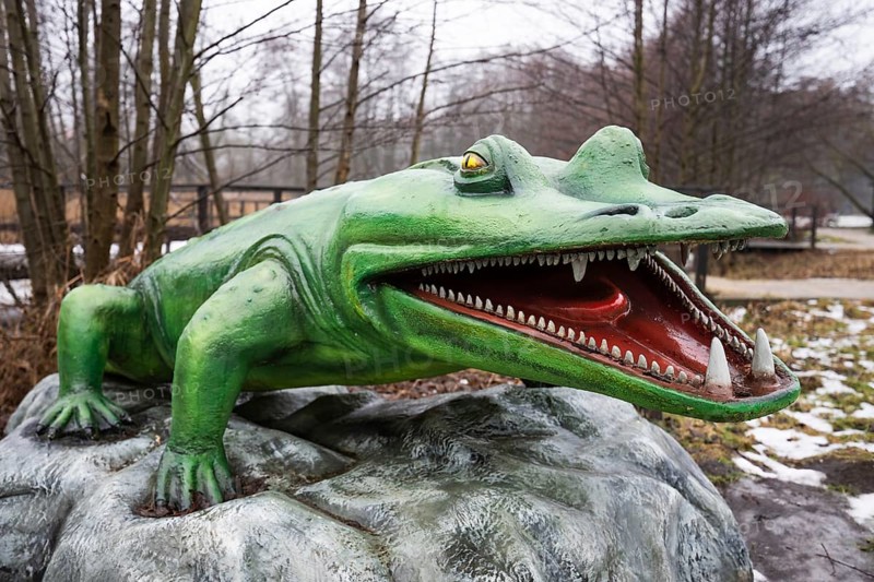 LUBIN, POLAND - JANUARY 15, 2026 - Realistic models of dinosaurs in Park Wroclawski. Life-sized realistic model of a Mastodonsaurus with open jaws showing sharp teeth, displayed in an outdoor prehistoric educational park during the winter season