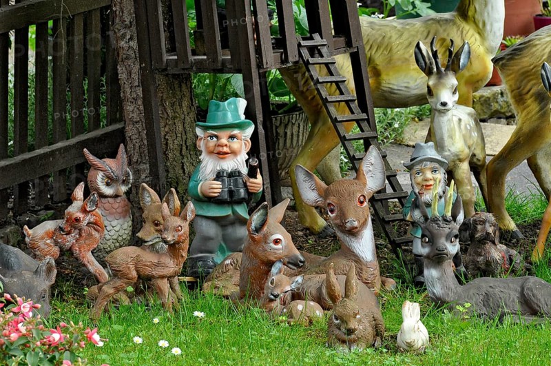 Garden gnomes, foresters with animals in the forest, in a front garden on a flower meadow with daisies in spring, Büdingen, Hesse, Germany