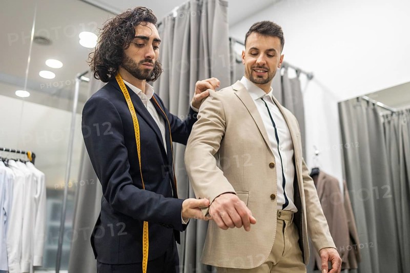 A professional tailor adjusts a client suit, ensuring perfect fit . The scene captures the precision involved in tailoring in a suit store