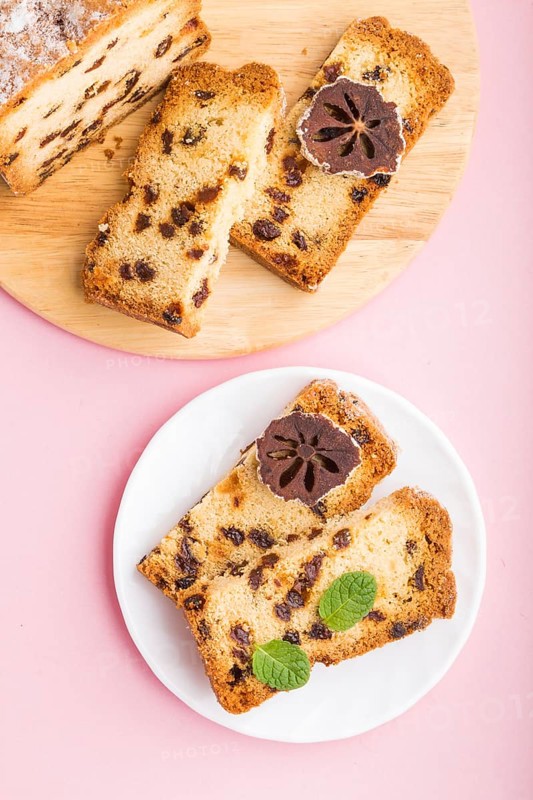 Homemade cake with raisins and dried persimmon on a pink pastel background. Top view, flat lay, copy space