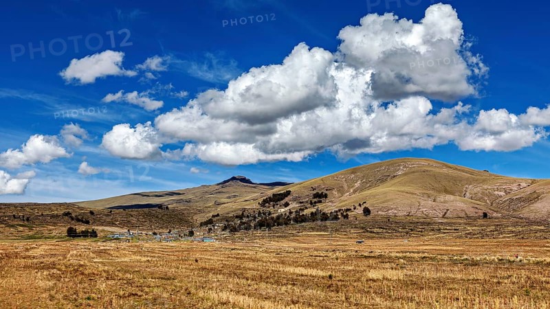 Wide, hilly landscape under a dramatic sky with powerful clouds, The villages and countryside near Puno in Peru