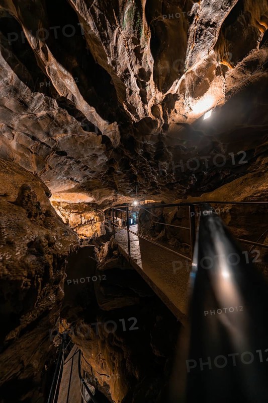 Illuminated path in a cave, surrounded by rocks and darkness, mysterious atmosphere, Beatus Caves, Switzerland