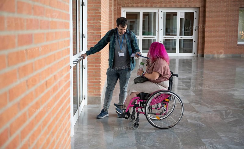 A couple in a college setting, focusing on accessibility The woman, who has a disability due to spina bifida, is in a wheelchair, highlighting support and inclusivity