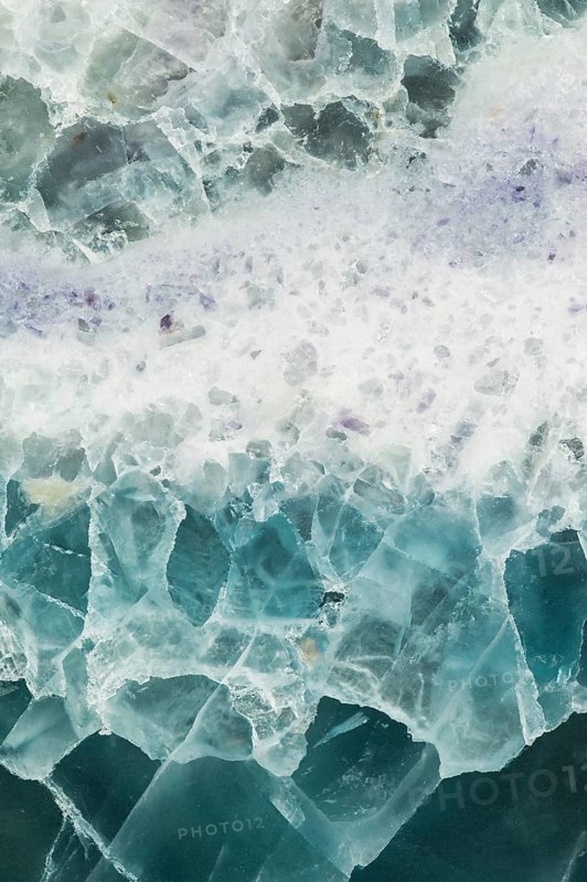 Detailed macro image of a fluorite, calcium fluoride, slab from China, featuring translucent layers of teal, white, and purple hues, with intricate crystal structures and natural formations
