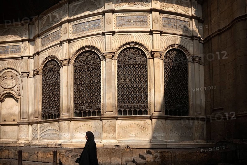 Cairo, Egypt. July 7th 2024 Egyptian woman walks past a restored Sabil, one of the monuments along Sharia Al Muizz Li Din Allah near Khan El Khalili Bazaar, historical Cairo, Egypt