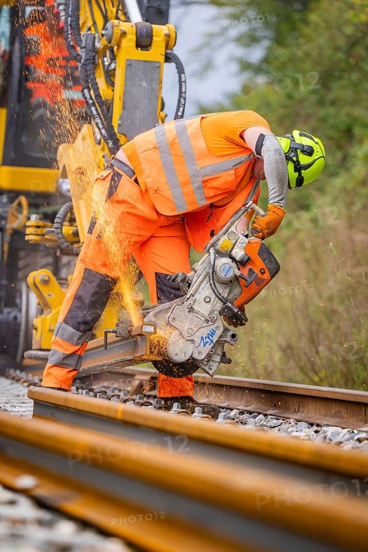 Construction worker with helmet cuts a track while sparks fly, track construction, Hermann Hessebahn, Calw, Black Forest, Germany