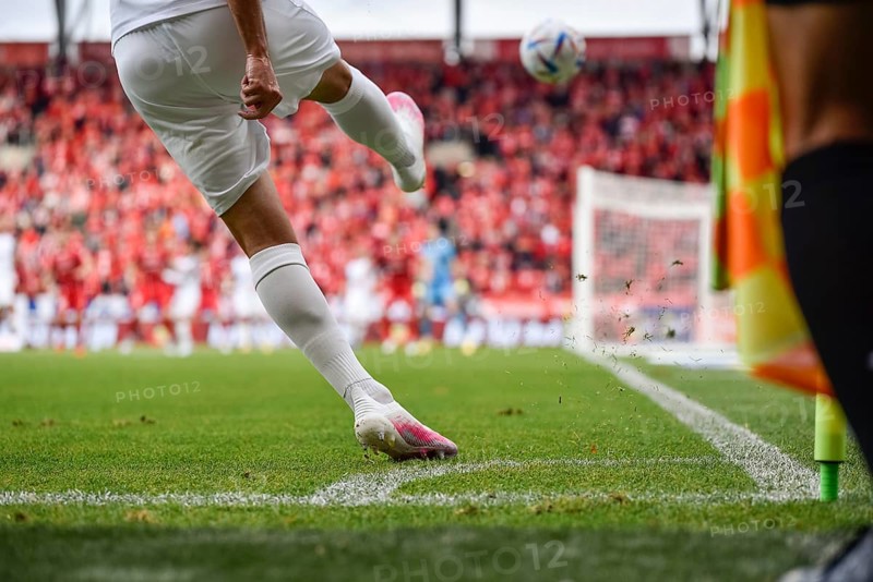 Footballer takes the corner. Detail of player's legs and the ball during soccer match in Lodz, Poland