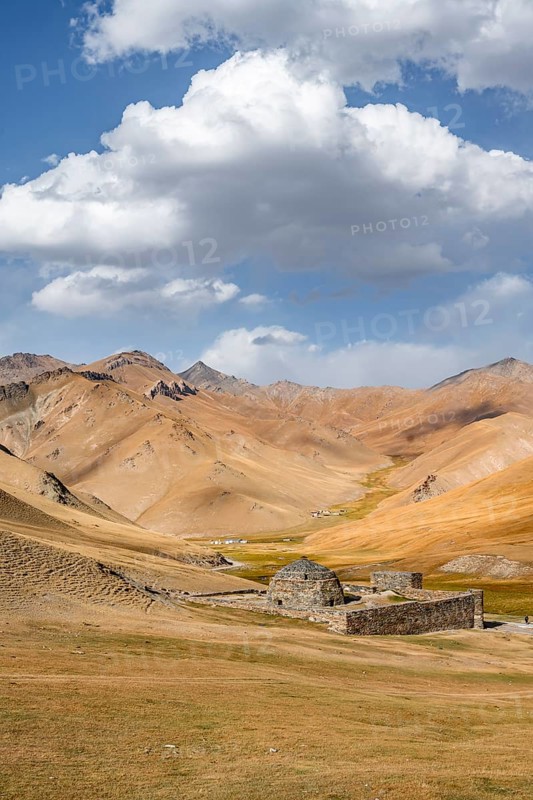 Historic caravanserai Tash Rabat from the 15th century, with yellow hills, Atbashy district in the Naryn region, Kyrgyzstan