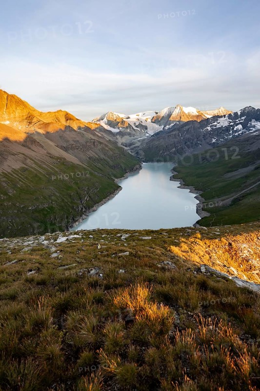 Picturesque mountain landscape at the summit Mont de la Blana at sunset, view of blue mountain lake, reservoir Lac des Dix and summit Mont Blanc de Cheilon with glacier, Hérémence, Valais, Western Alps, Switzerland