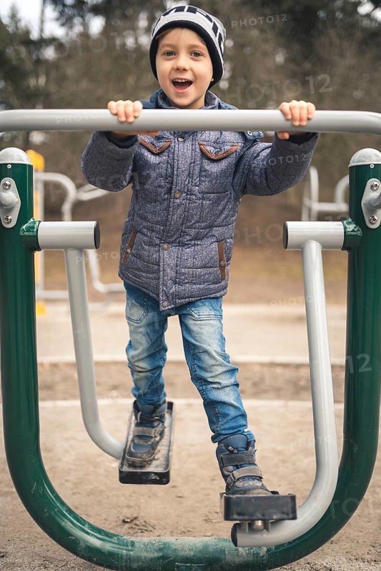 Young boy smiling and exercise at the outdoor gym in Wroclaw, Poland