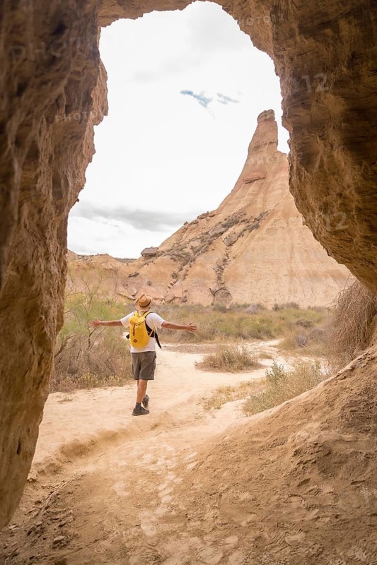 Vertical photo true an cave of a free man walking along a desert alone