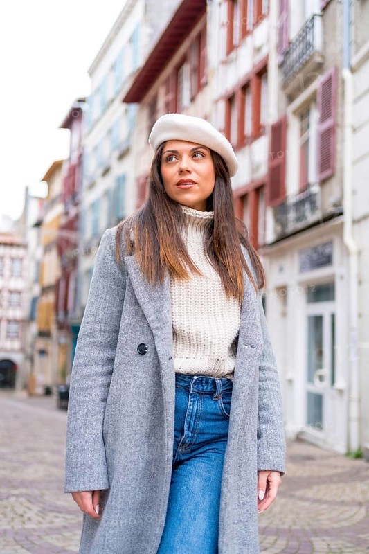 Vertical photo of a french style tourist standing in a street looking at views