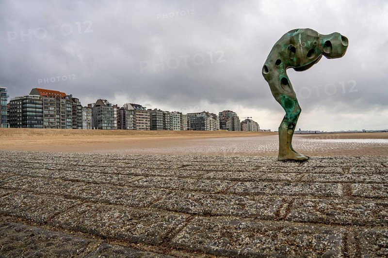 Art on the North Sea beach, in Knokke-Heist, Tomorrow Man by Cathérine François, is washed over by the sea at high tide, many permanent works of art in public spaces are spread around the city, here on the beach on Zeedijk-Knokke, beach promenade, dreary winter day, Belgium