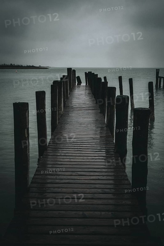 Jetty juts out into a gloomy, cloudy lake, Podersdorf, Burgenland, Austria