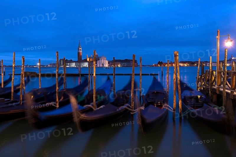 Nighttime atmosphere with moving gondolas, San Georgio Maggiore in the back, Guidecca Island on the right, Venice, Italy