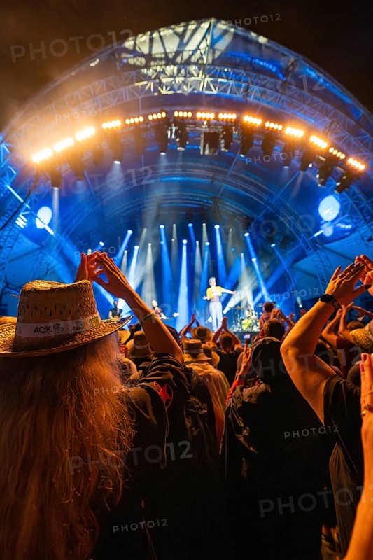 At night at a concert, people with hats, illuminated stage with blue lights and music performance, Klostersommer, Calw Hirsau, Black Forest, Germany