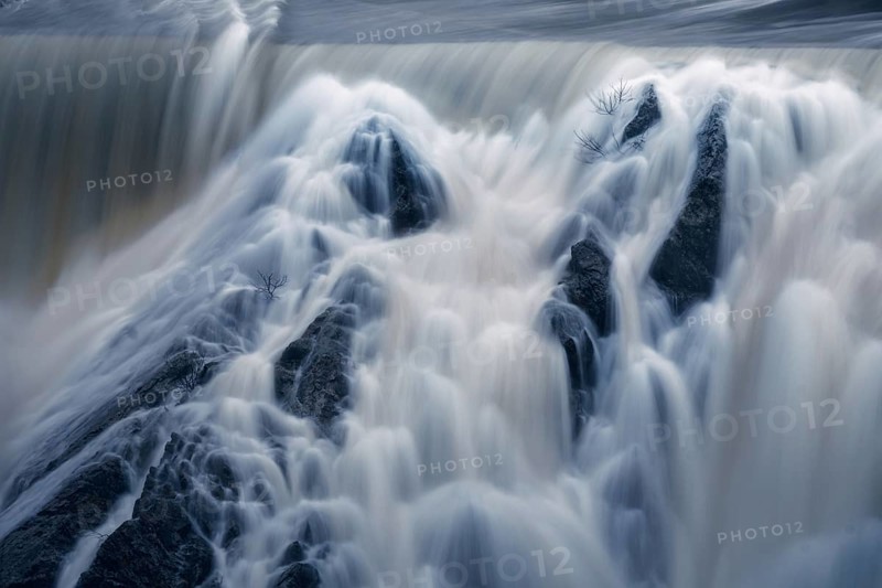 Cascading waters of Presa del Villar in Madrid captured using a long exposure technique, presenting a surreal and smooth waterfall effect