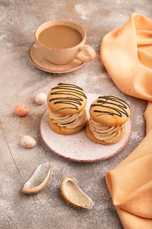 Caramel Cream Cakes on brown concrete background, cup of coffee, side view, close up