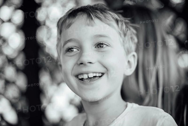 Black and white outdoor portrait of a cute seven years old boy