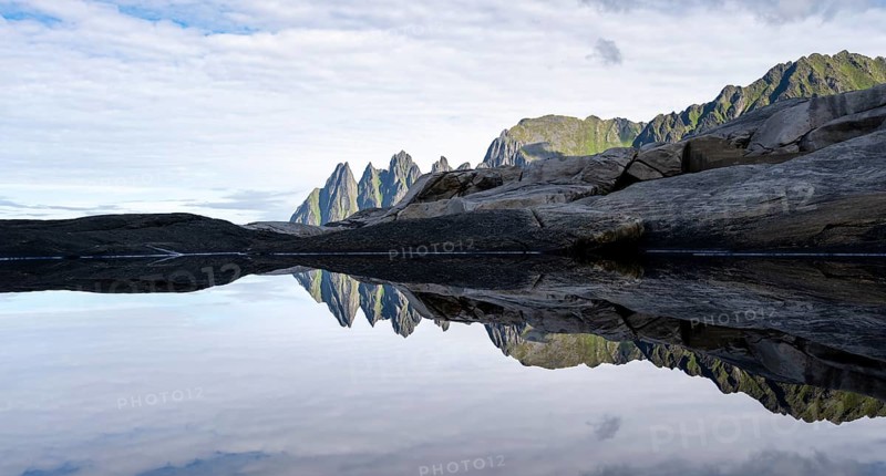 Reflection in a tidal pool, rocky coast of Tungeneset, Devil's Teeth, Okshornan, Ersfjorden, Senja Island, Troms, Norway