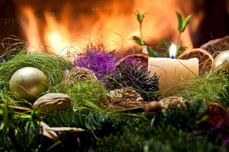 Christmas decoration with a candle and fireplace in the background in Poland