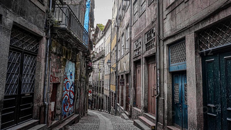 Narrow alley with cobblestones and historic buildings in the atmospheric old town of Porto, Portugal