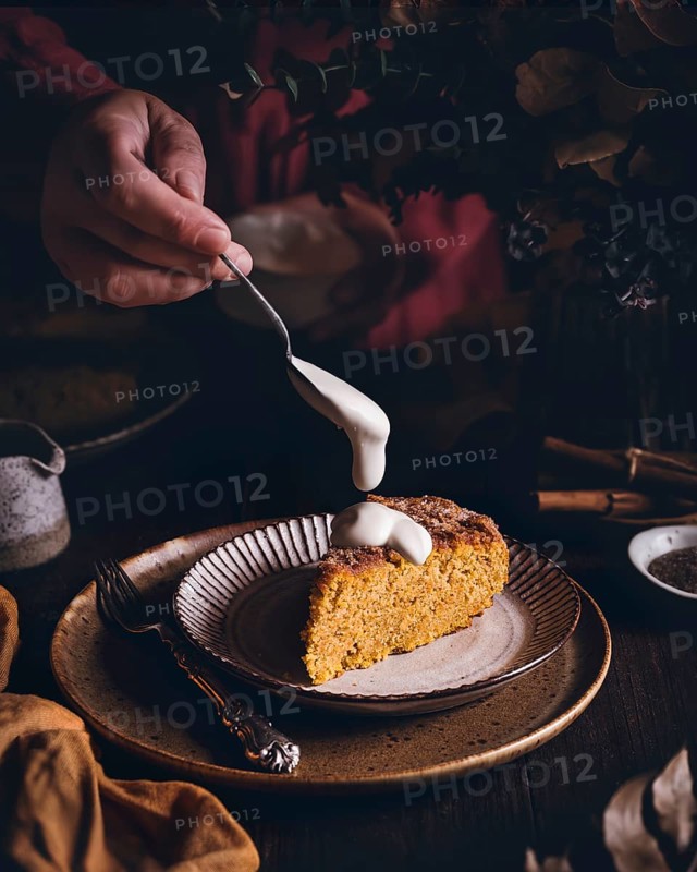 A delightful slice of pumpkin and cinnamon sponge cake, topped with a generous drizzle of creamy icing. Perfect for autumn gatherings or a cozy dessert treat