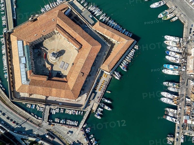 Drone captures of the pentagonal Lazzaretto of Ancona surrounded by harbor waters and boats. This historic Italian quarantine station now serves cultural and civic functions in the city