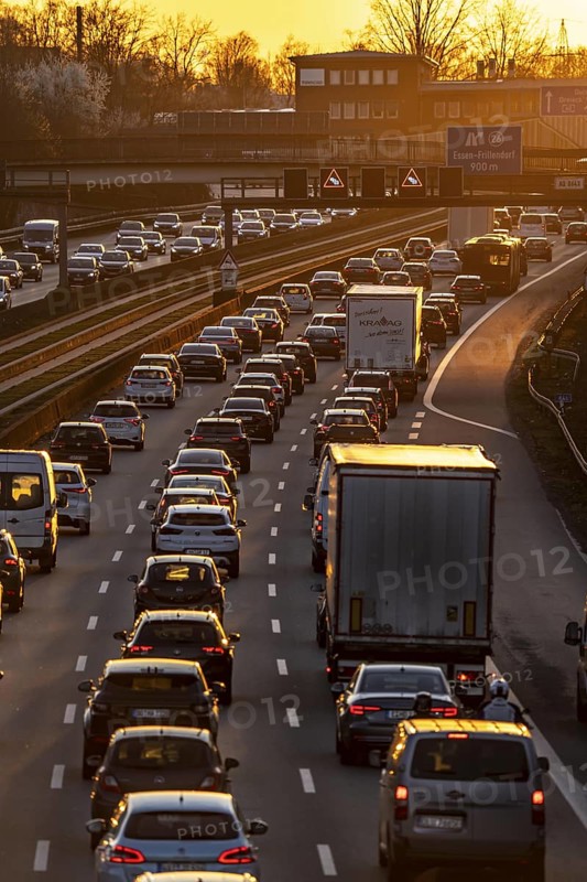 Motorway A40, dense, slow-moving traffic jam, evening traffic at the Essen-Kray junction, low sun, public transport bus lane in the middle of the motorway, North Rhine-Westphalia, Germany