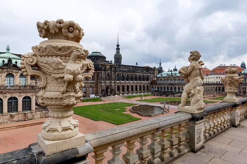 Majestic view of Zwinger Palace in Dresden, Germany, showcasing its intricate Baroque architecture and ornate sculptures under a cloudy sky, emphasizing its historical grandeur