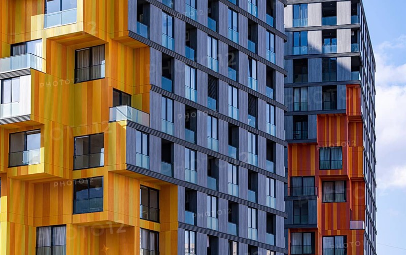 This image showcases the modern architectural elements of a suburban building, highlighting a dynamic combination of glass, concrete, and metal materials in its construction