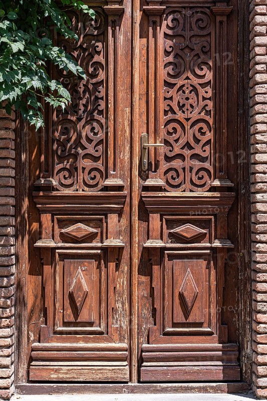 A beautifully carved wooden door in Tbilisi, featuring ornate patterns and detailed craftsmanship. The door highlights the charm and history of the city's old town architecture