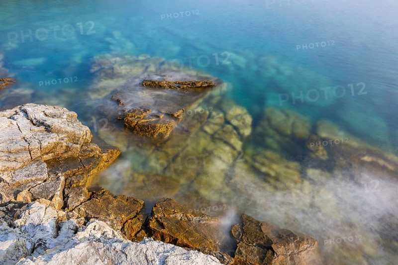 Crystal clear and turquoise water on the beach of Ustrine Bay on a sunny day on the island of Cres, long exposure, Croatia