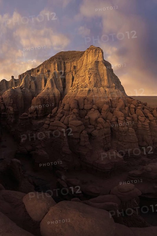 Majestic sandstone formations in Goblin Valley State Park, Utah, showcase nature's artistry with their unique shapes and textures, surrounded by a dramatic sky at dusk