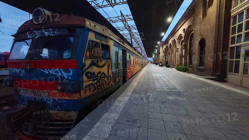 A train on the station track with artistic graffiti as darkness sets in, Yerevan, Armenia