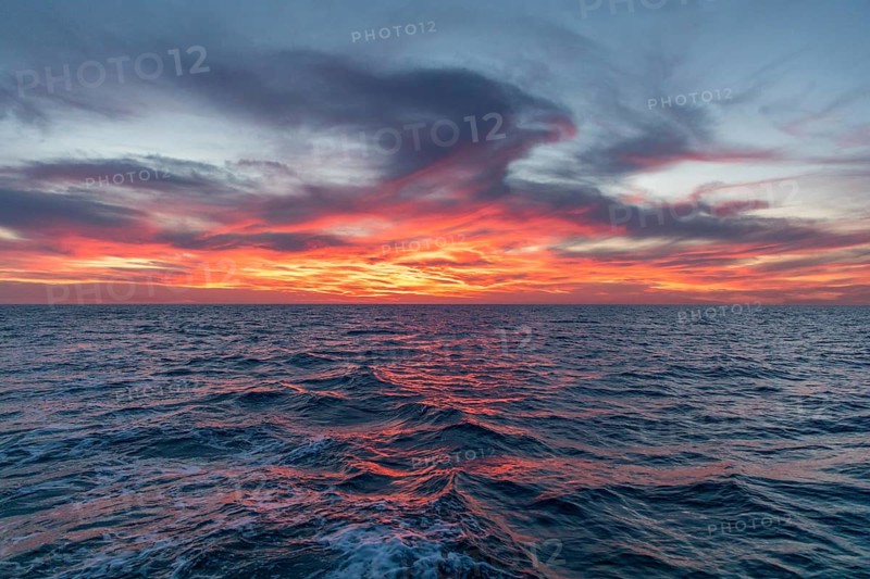 Captivating view of the Mediterranean sea during sunset or sunrise at Costa Blanca, showcasing vibrant sky hues reflecting on the calm waters and creating a tranquil atmosphere