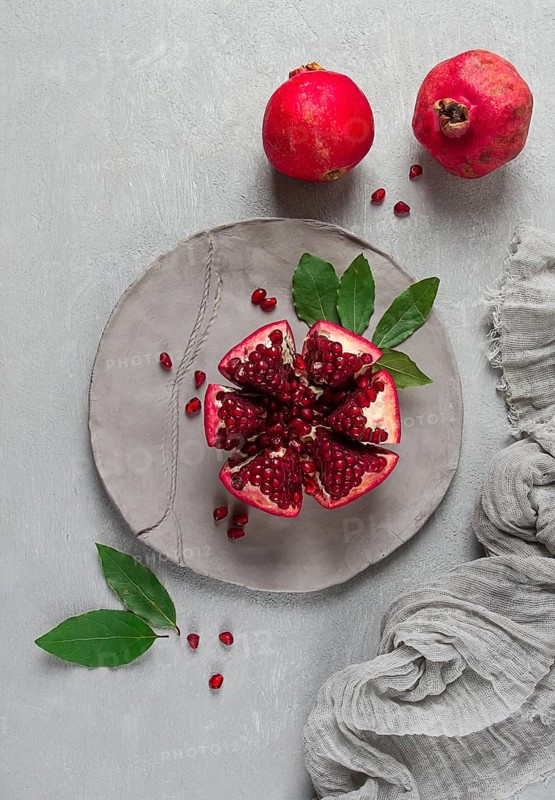 Fresh, cut pomegranate fruit, on a gray background, food concept, top view, no people